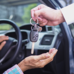 Předání klíčů od auta mezi lidmi u otevřeného vozu